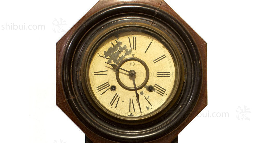 closeup of weathered clock face set in octagon frame