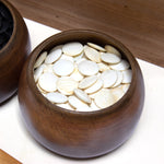 Kitani goke holding clamshell (white) goishi (go stones).